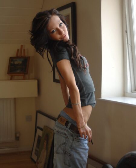 Brunette solo girl Rosie covers her private parts after getting totally naked